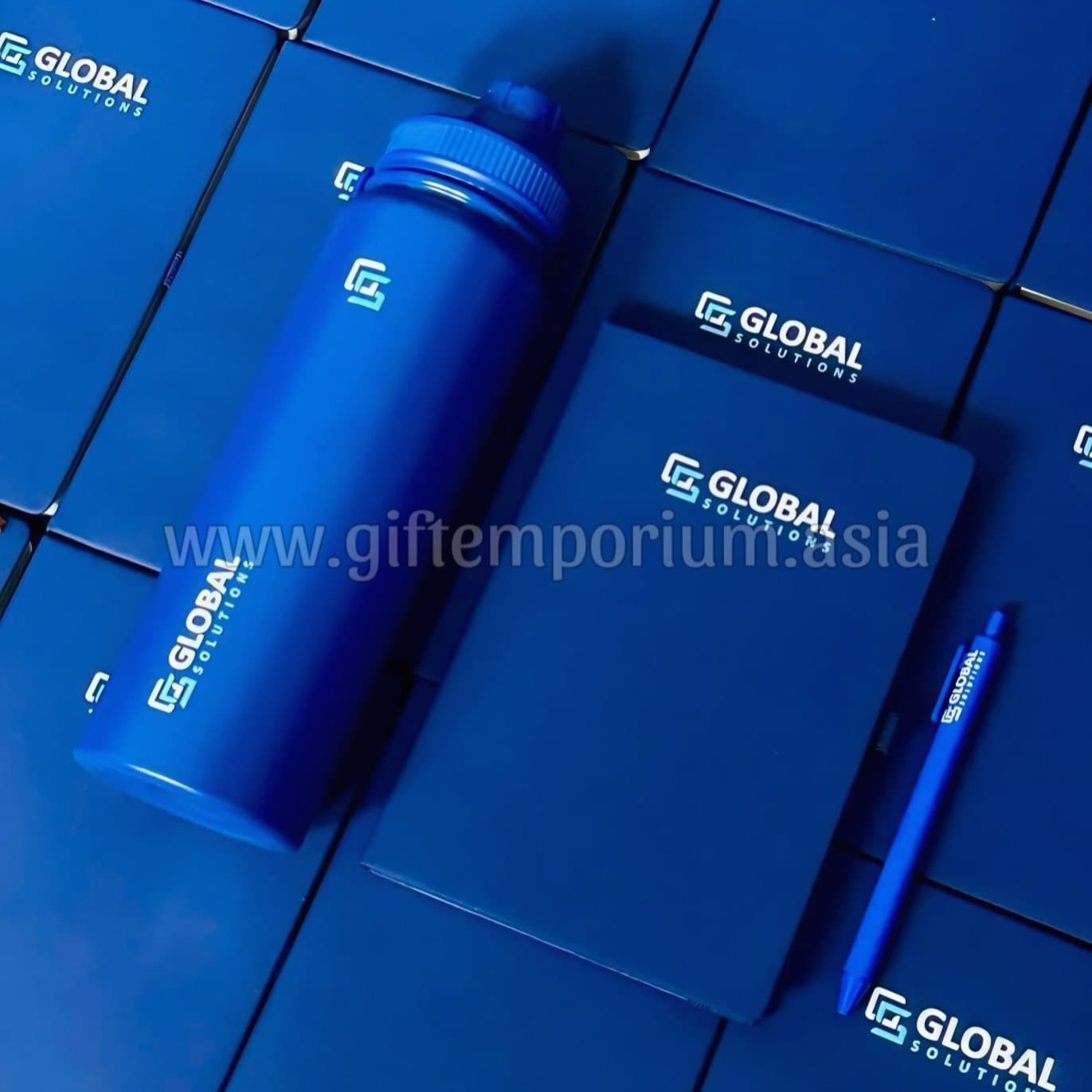 Blue branded corporate gift set — tumbler, notebook, and pen for Global Solutions